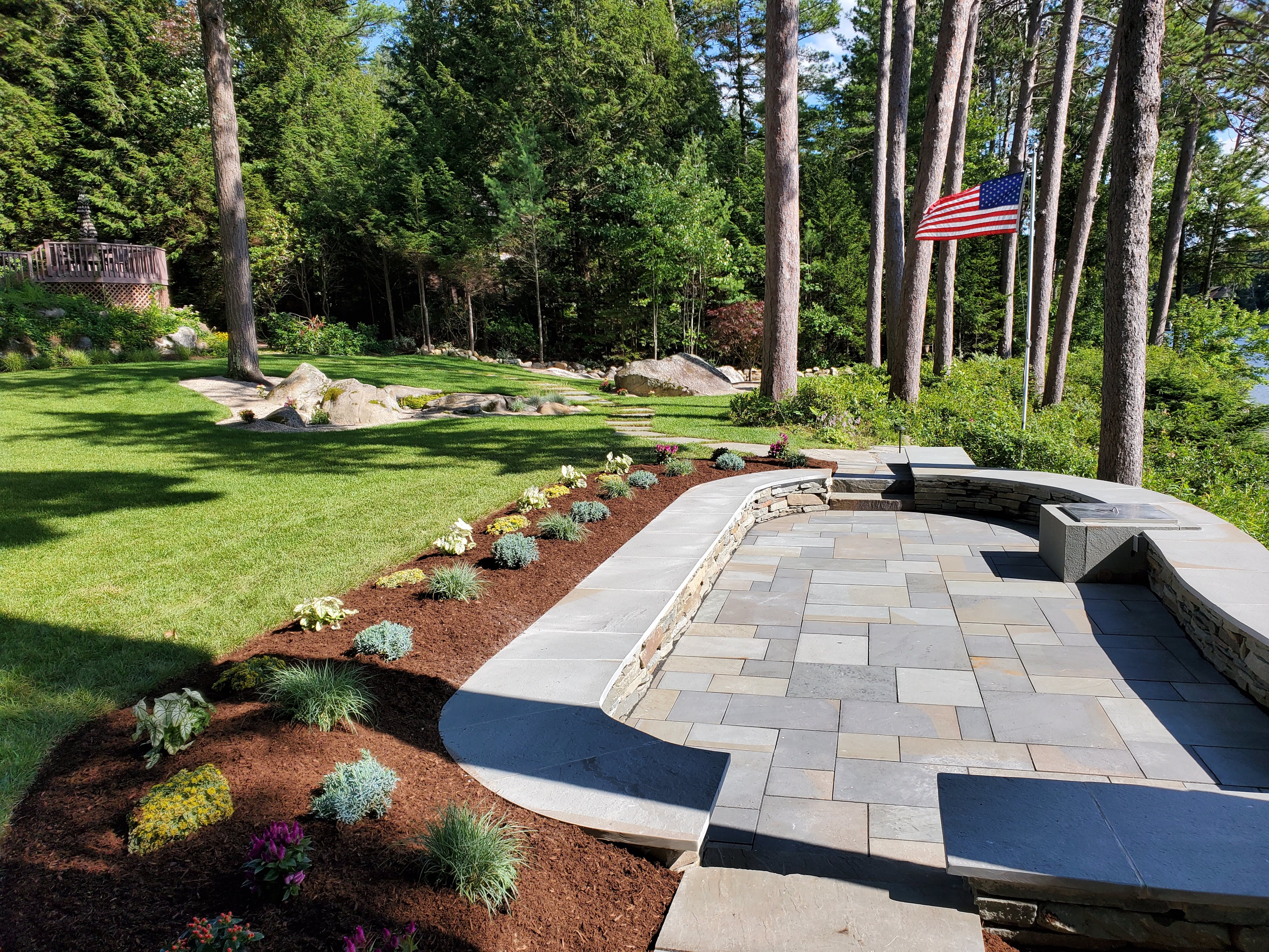 Finished bluestone patio with stacked stone seat wall and flag