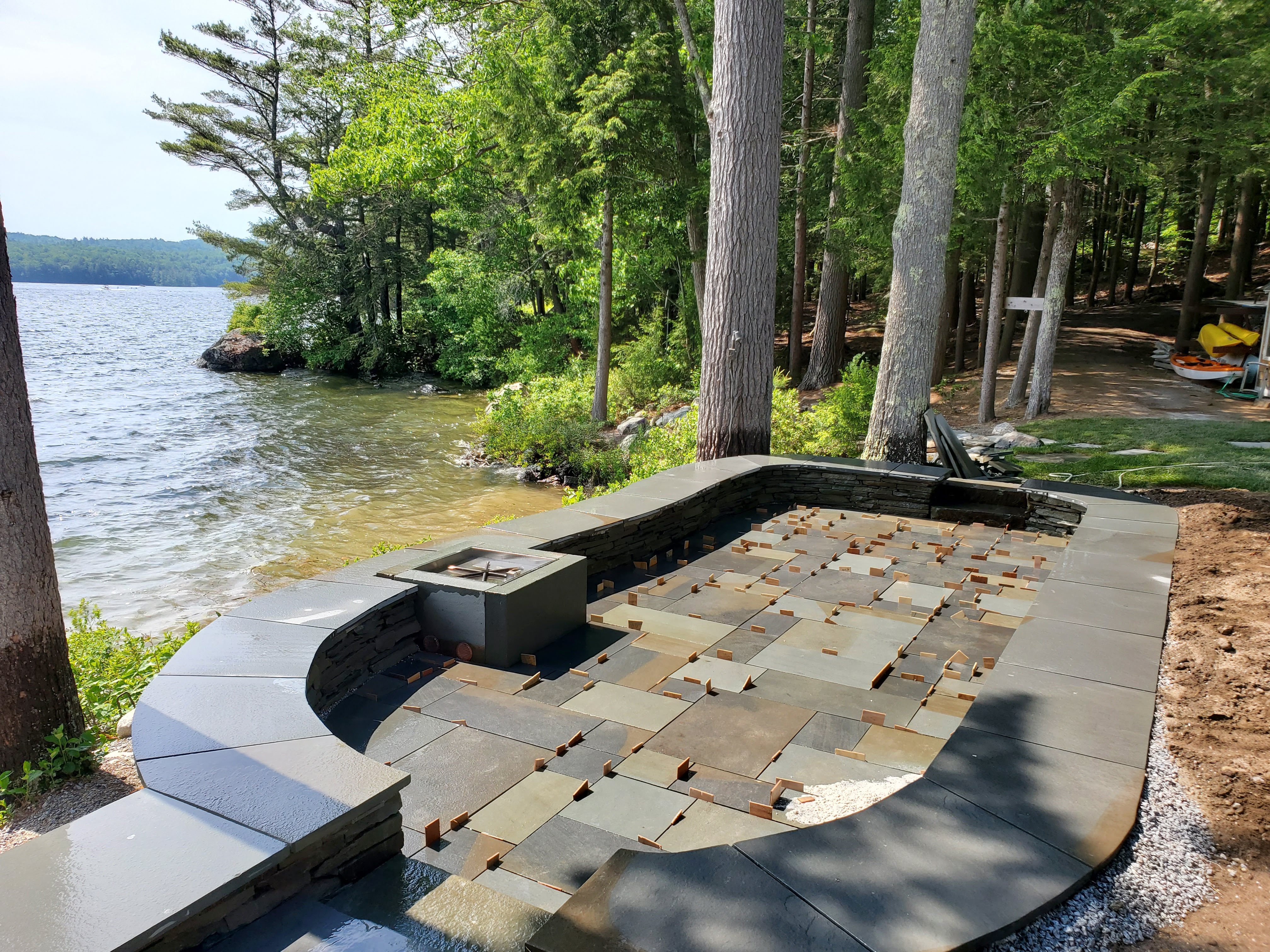 Bluestone pavers being laid out for a lakeside patio install