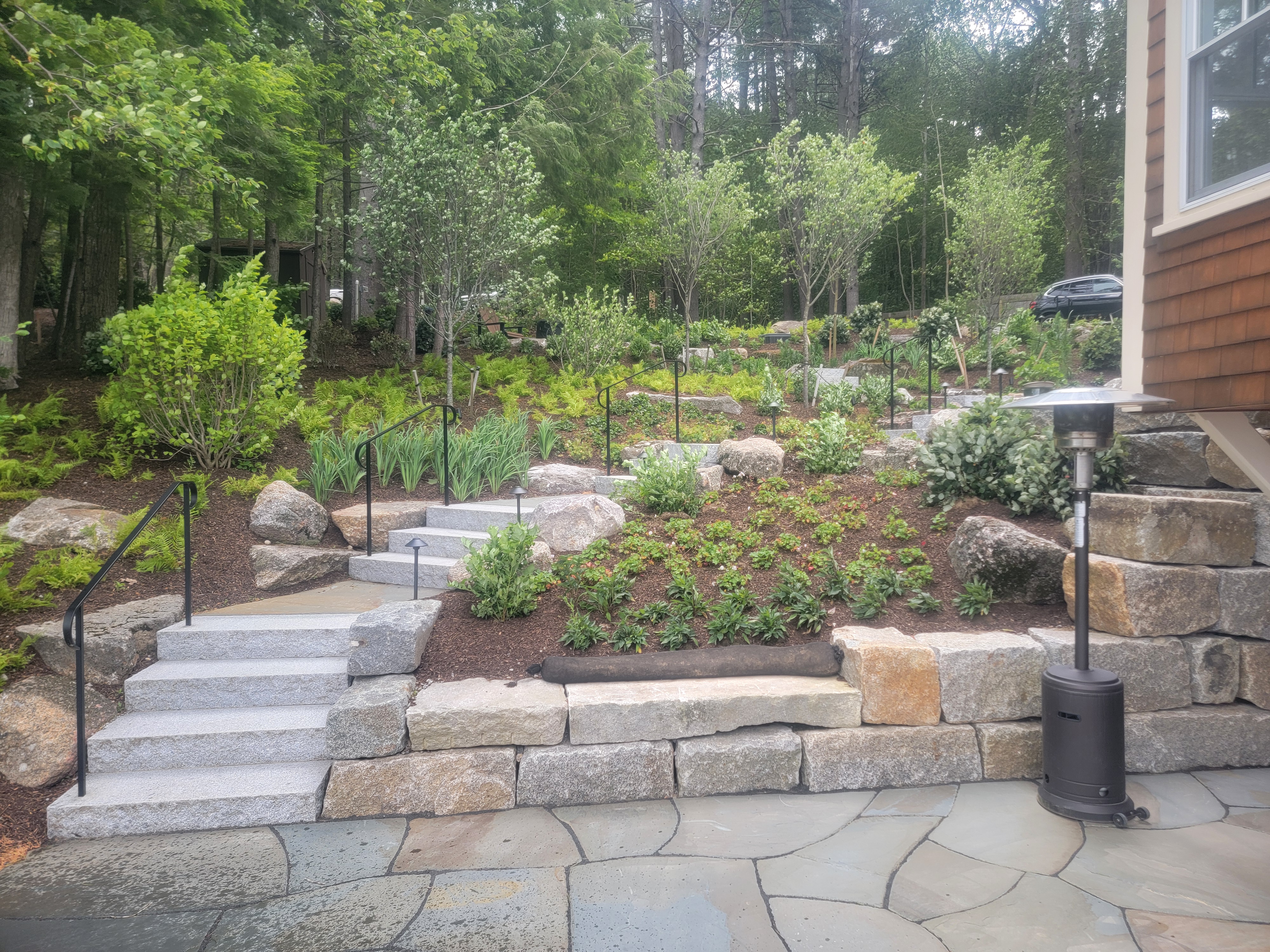 Clean granite step run with iron railings and new plantings