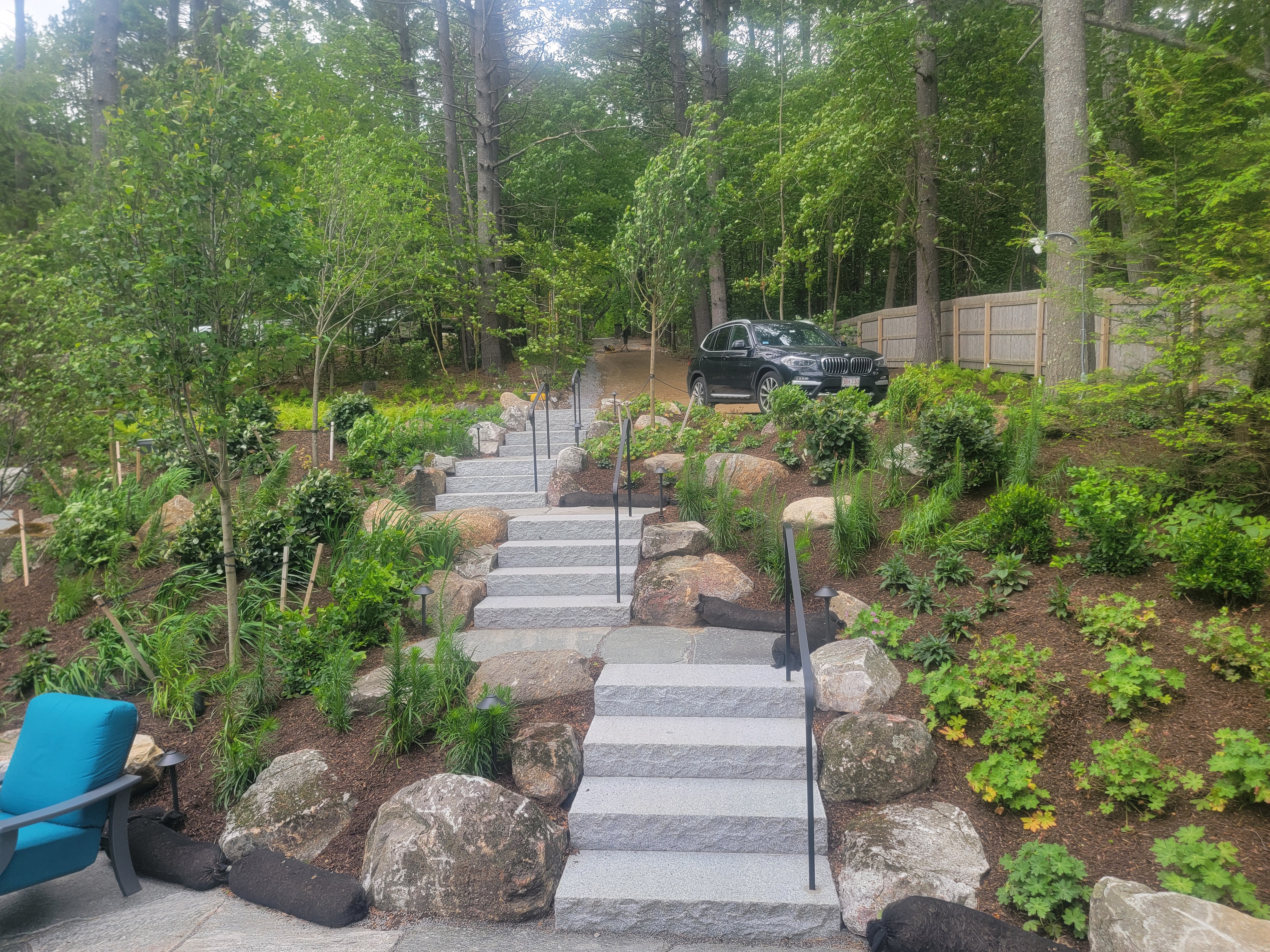 Two flights of granite steps zig-zagging up a wooded slope