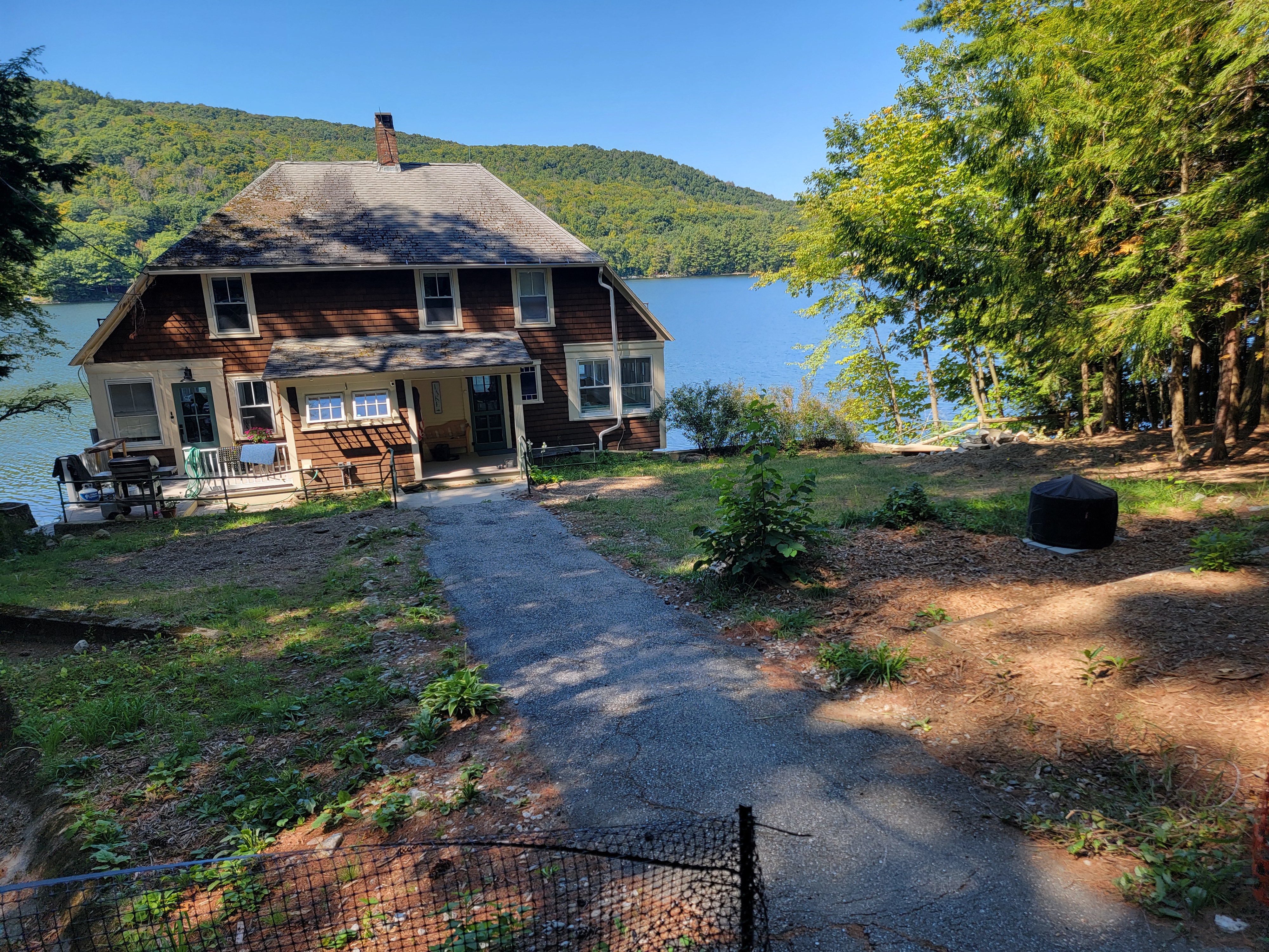 Worn dirt approach to a lakefront home before walkway install