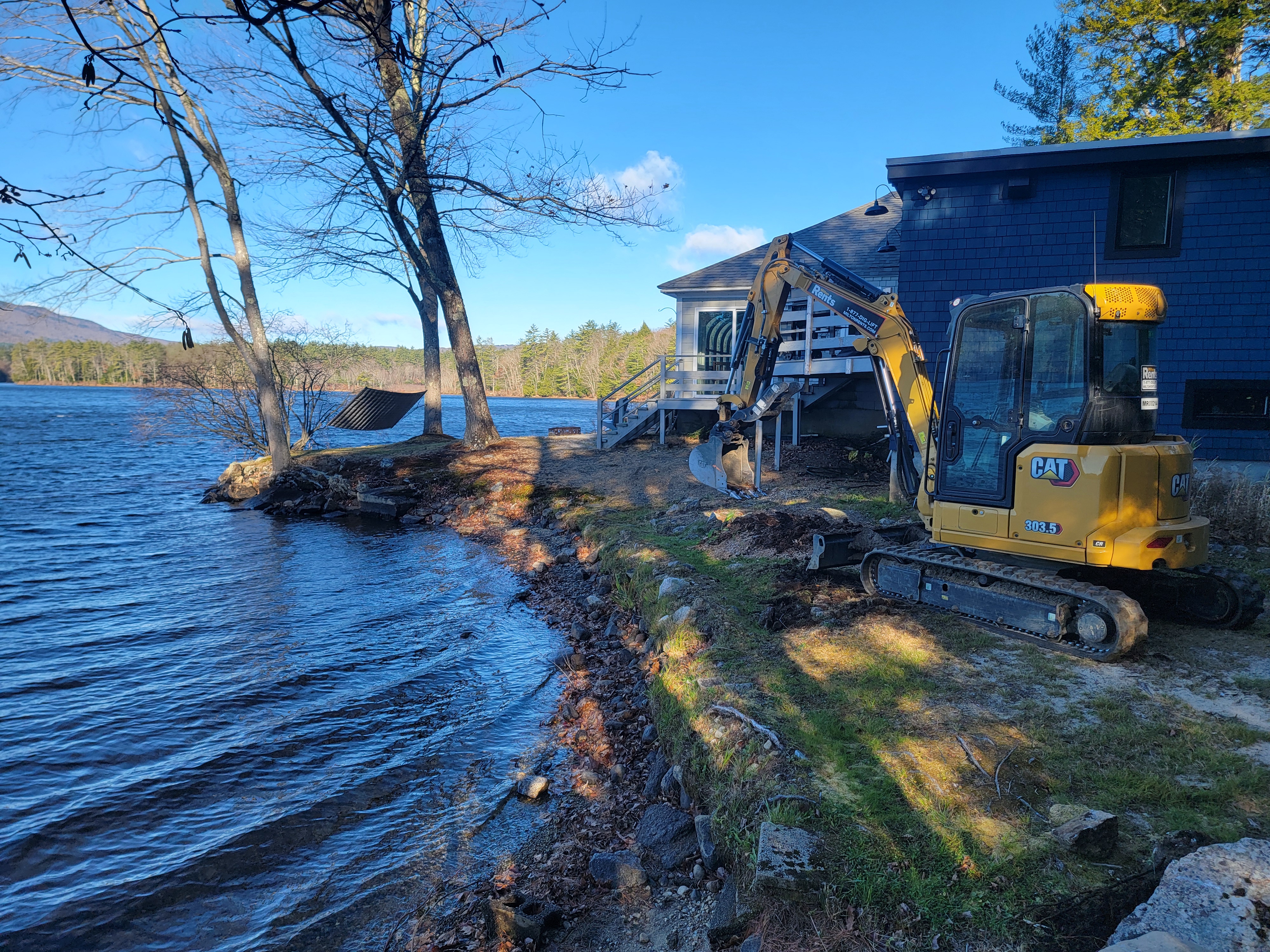 Cat 305 excavator beside a lakefront home rebuilding the shoreline