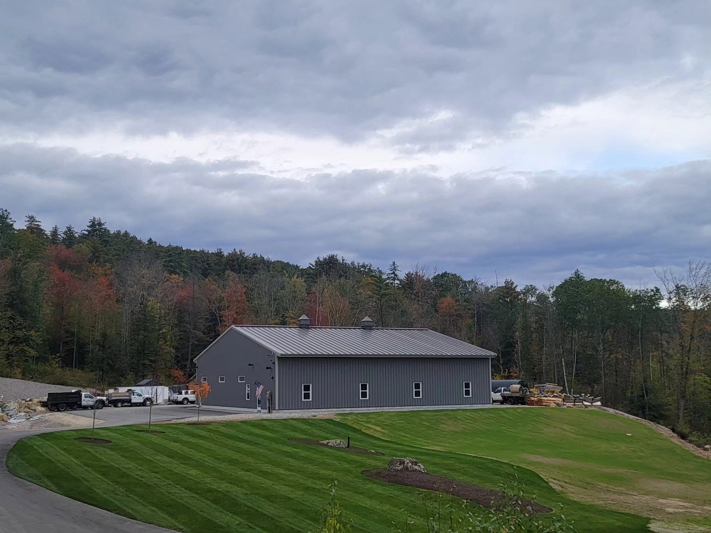 Tyler Lawn Care facility in Warner, NH with striped lawn and fall foliage